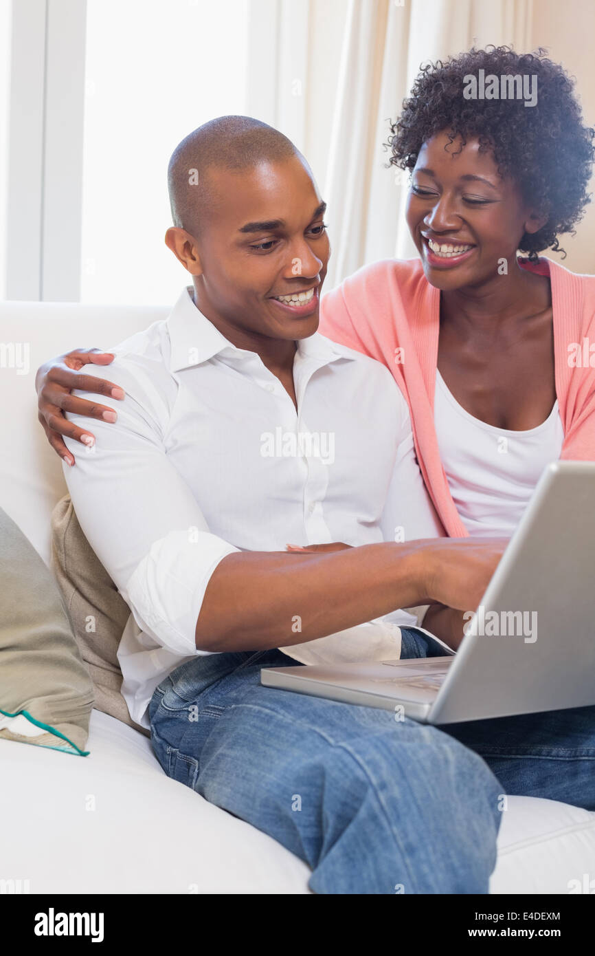 Cute couple relaxing on couch with laptop Stock Photo - Alamy