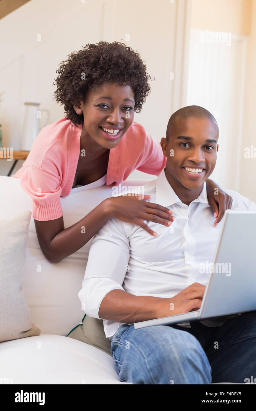 Cute couple relaxing on couch with laptop Stock Photo - Alamy