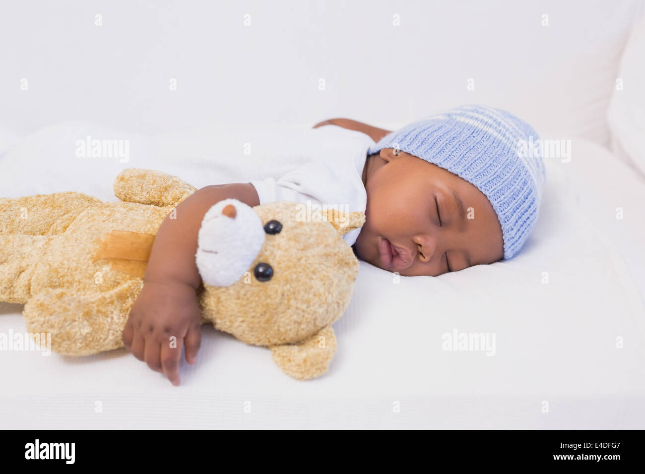 Adorable baby boy sleeping peacefully with teddy Stock Photo