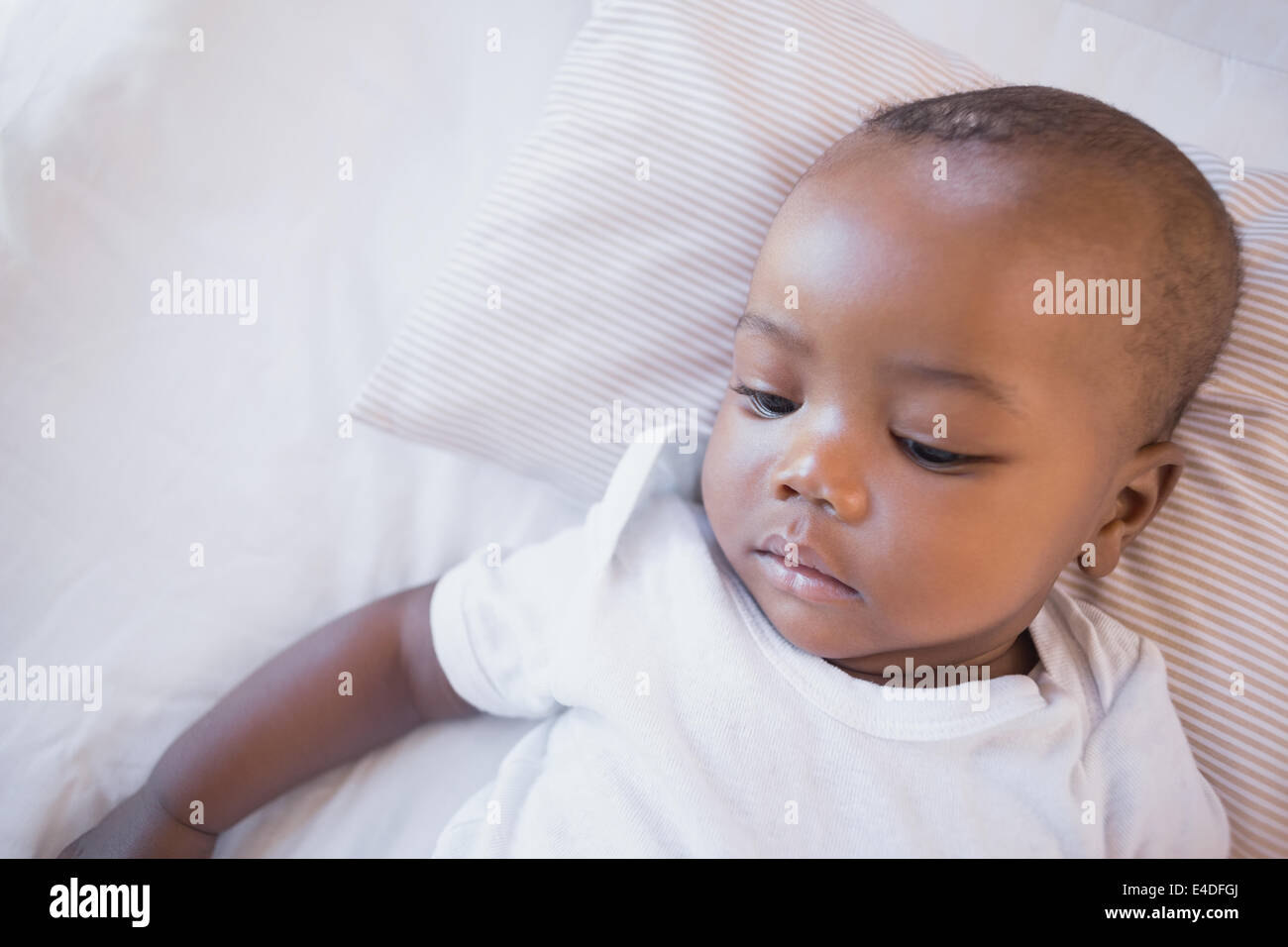 Adorable baby boy lying in his crib Stock Photo