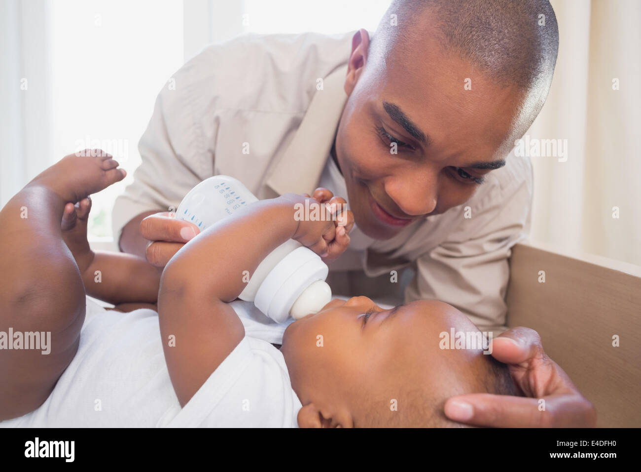 Happy father feeding his baby boy Stock Photo