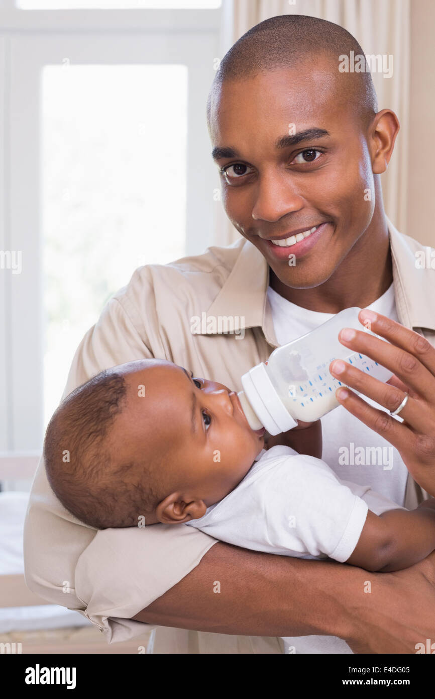 Happy father feeding his baby boy a bottle Stock Photo