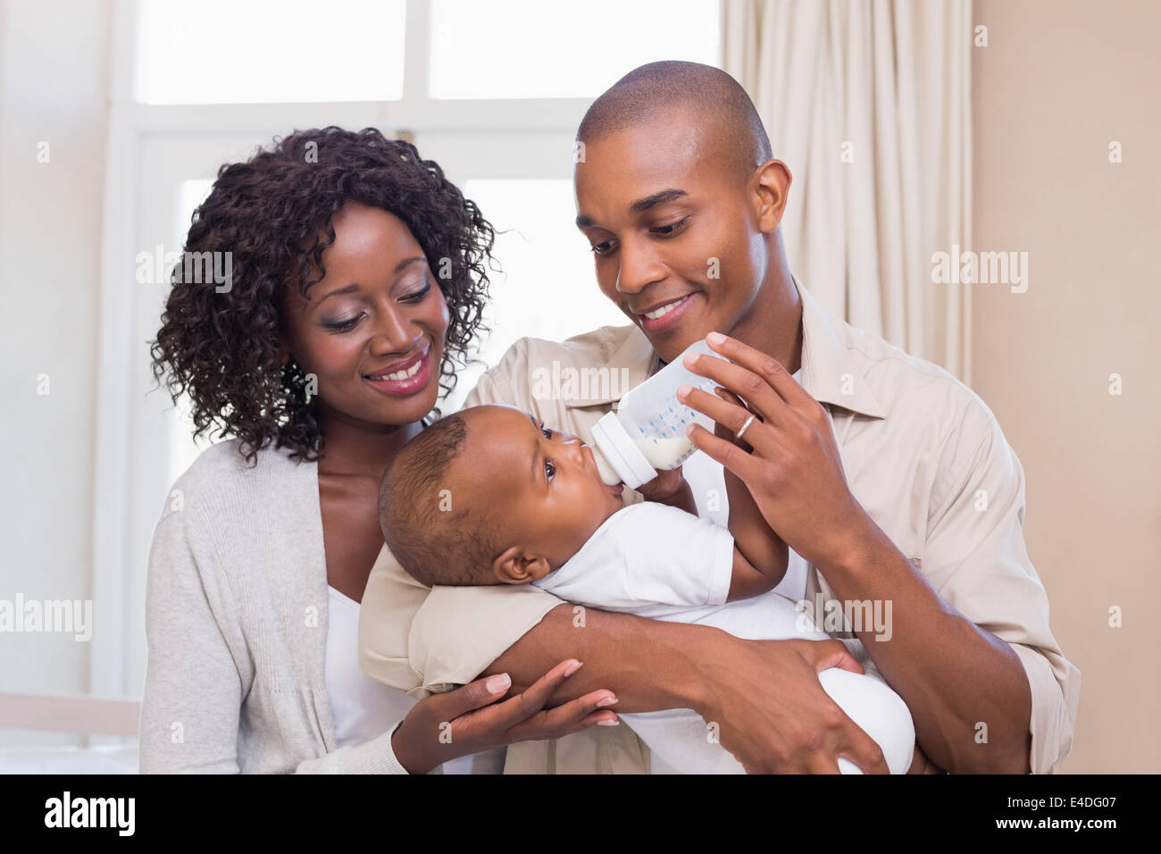 Happy parents feeding their baby boy a bottle Stock Photo