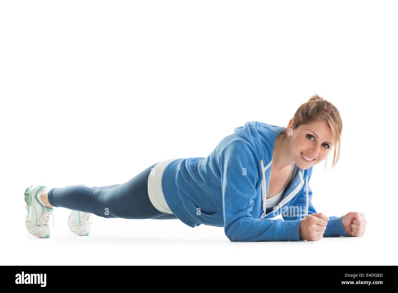 Smiling young woman in basic plank posture Stock Photo