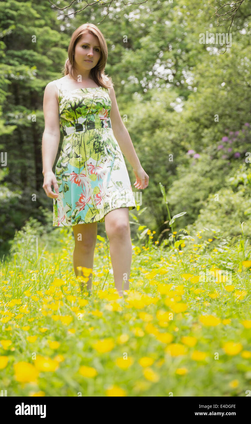 Cute young woman standing in field Stock Photo - Alamy
