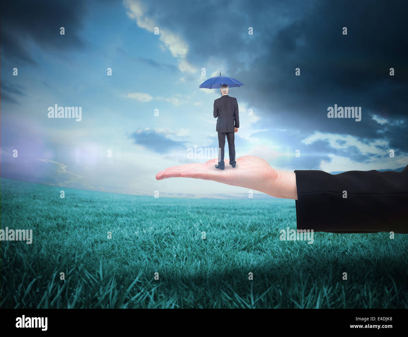 Composite image of businessman holding umbrella Stock Photo