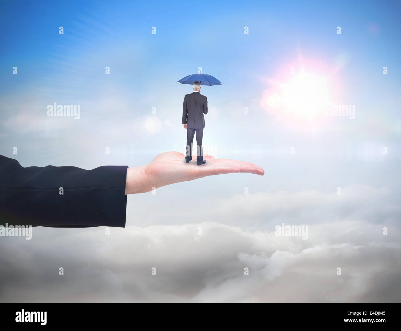 Composite image of businessman holding umbrella Stock Photo