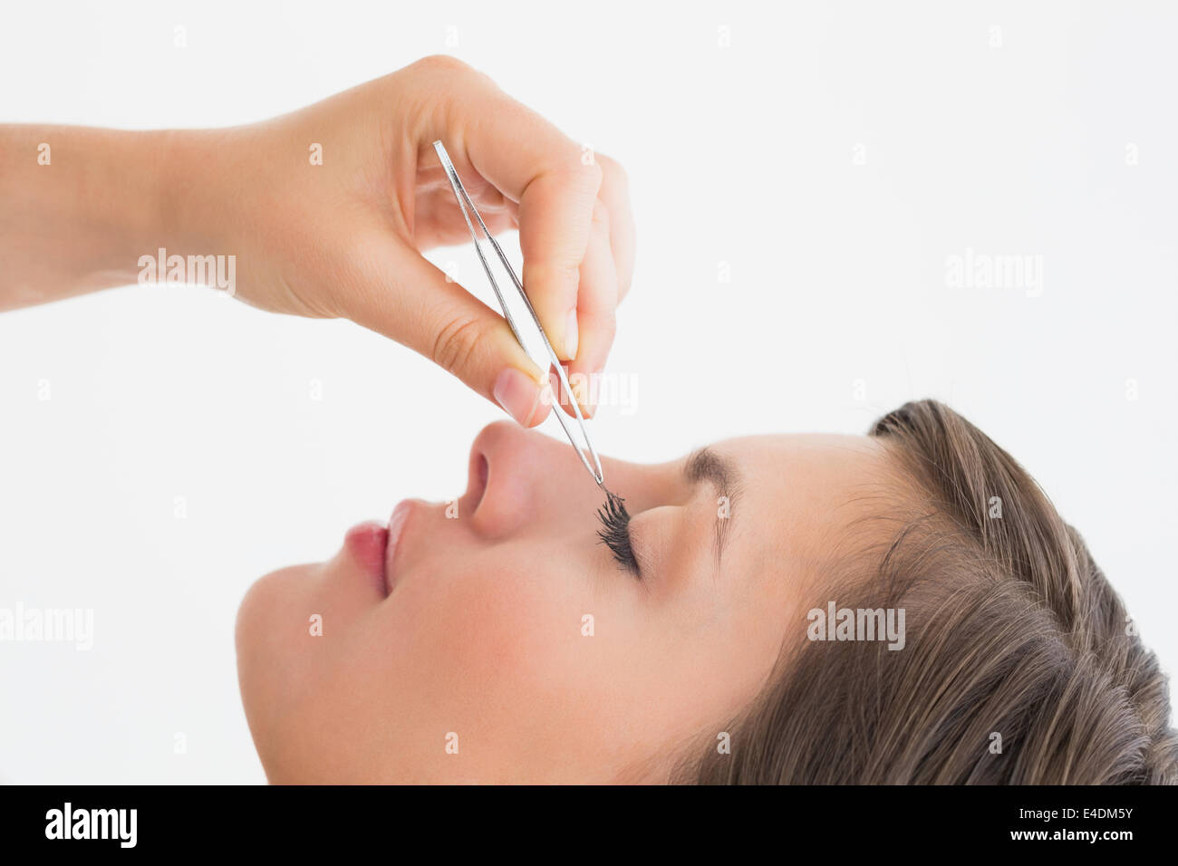 Close-up side view of hand plucking eyelashes Stock Photo