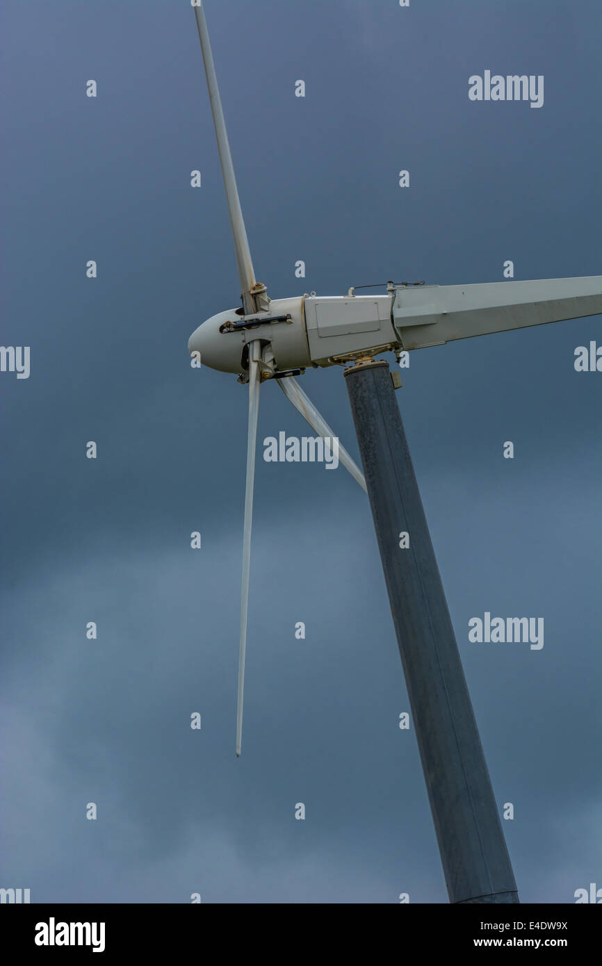 Wind turbine / wind generator set against brooding / foreboding dark clouds. A 'renewable' form of power useful in the climate change energy mix. Stock Photo