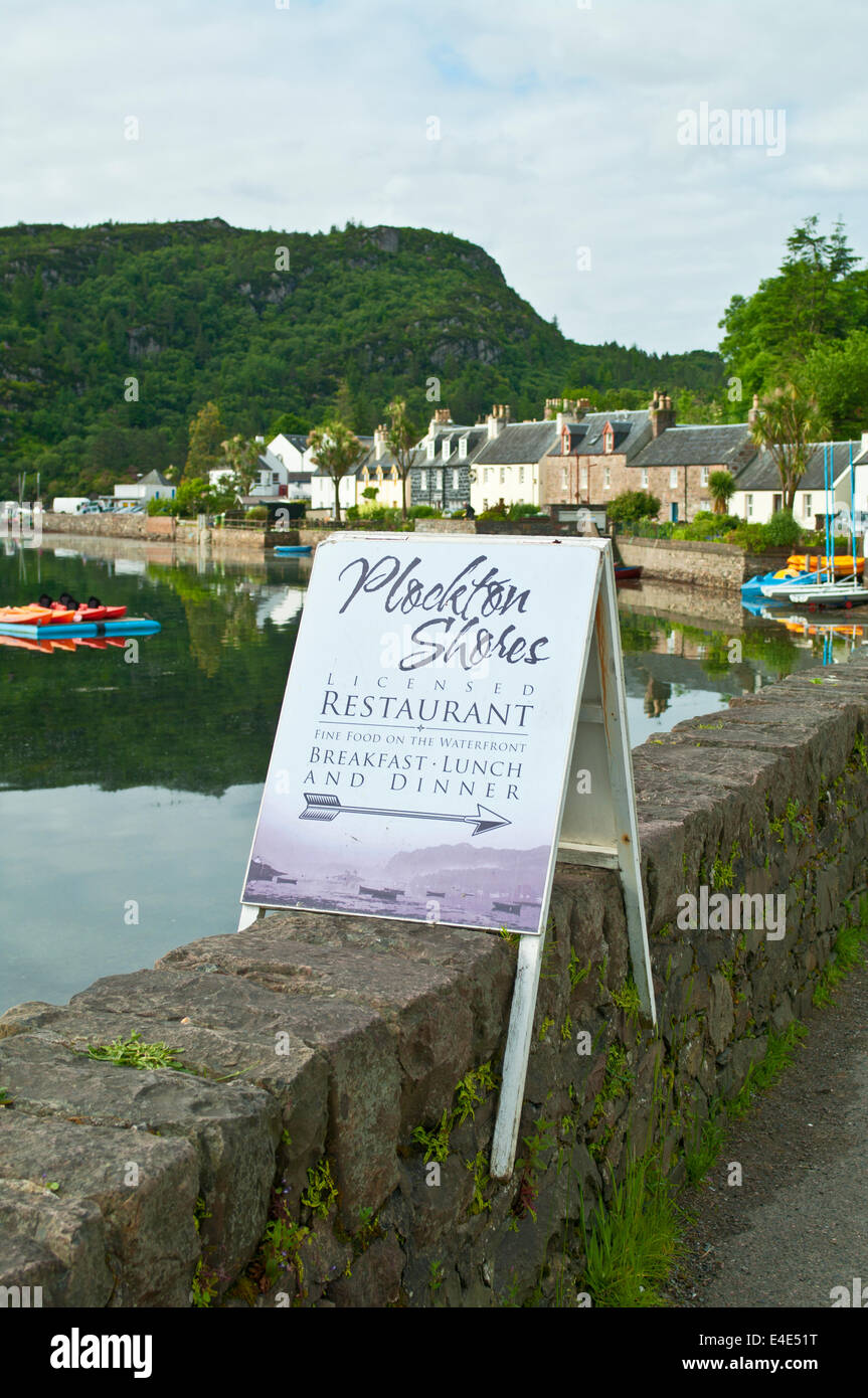 Wooden sign advertising Plockton Shores Restaurant on harbour wall in Plockton village, Loch Carron, Wester Ross, Scotland, UK Stock Photo