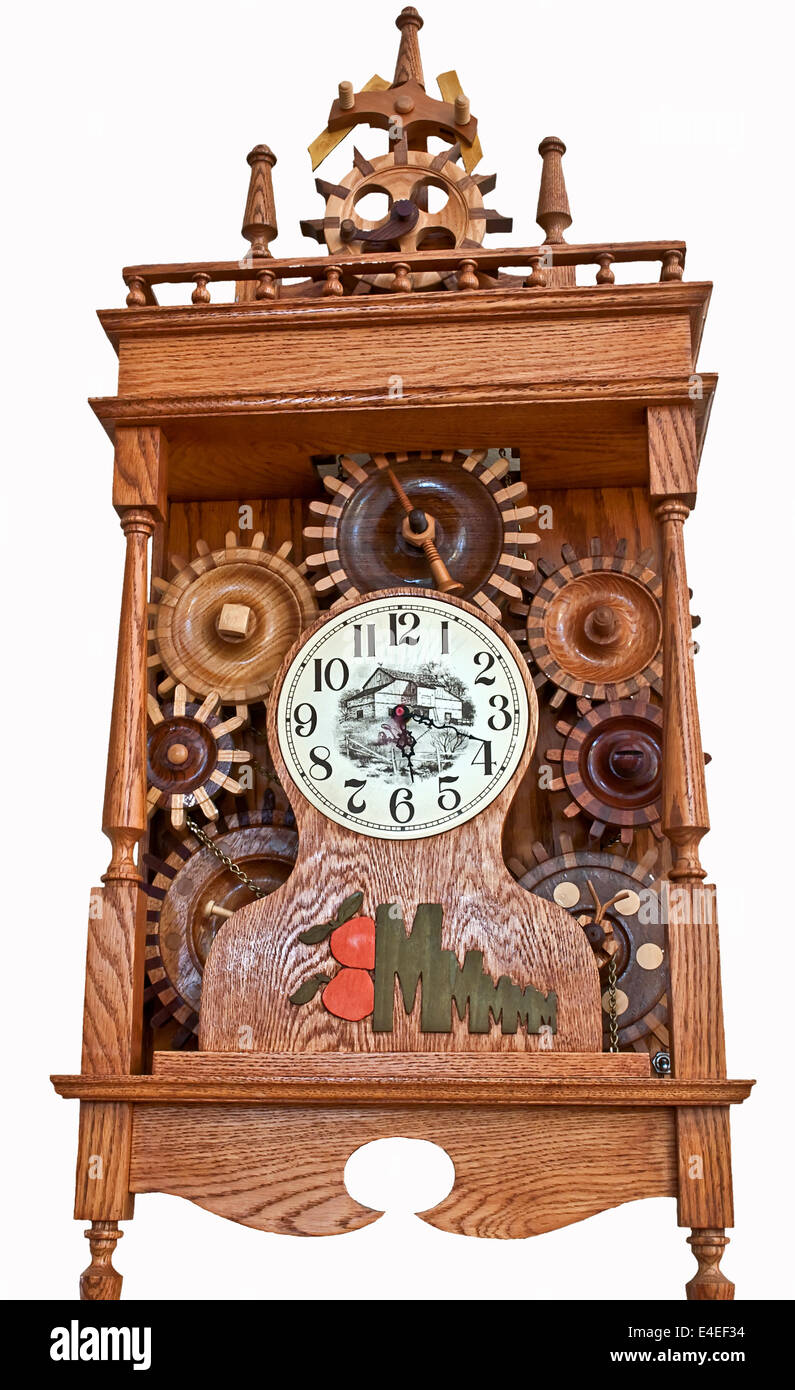 Vintage wooden clock with detailed gears and a European Scandinavian old world style in this home related object on white background. Stock Photo