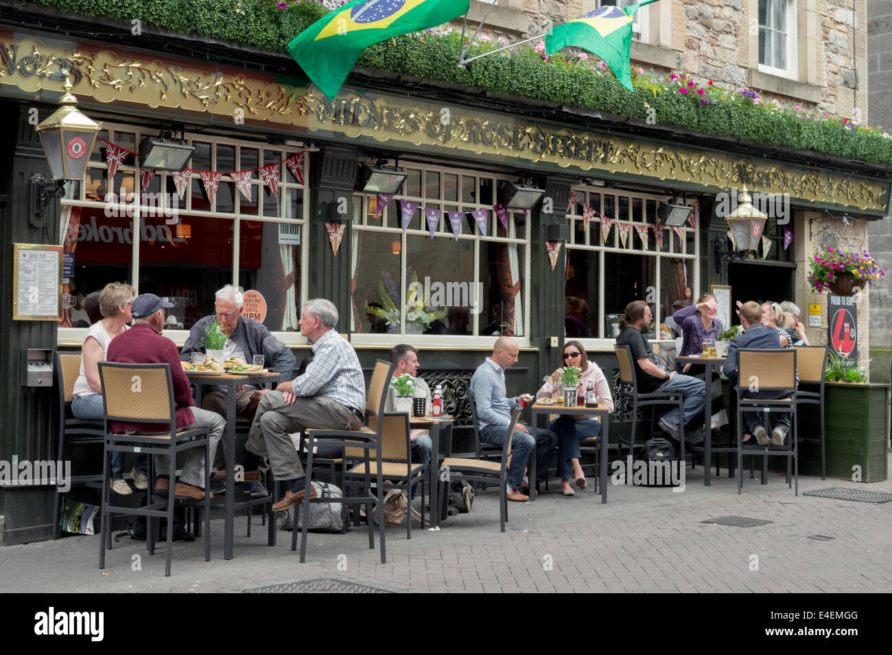 Shoppers and tourists enjoying a meal and a drink outside of Milnes Bar, Rose Street, Edinburgh Stock Photo