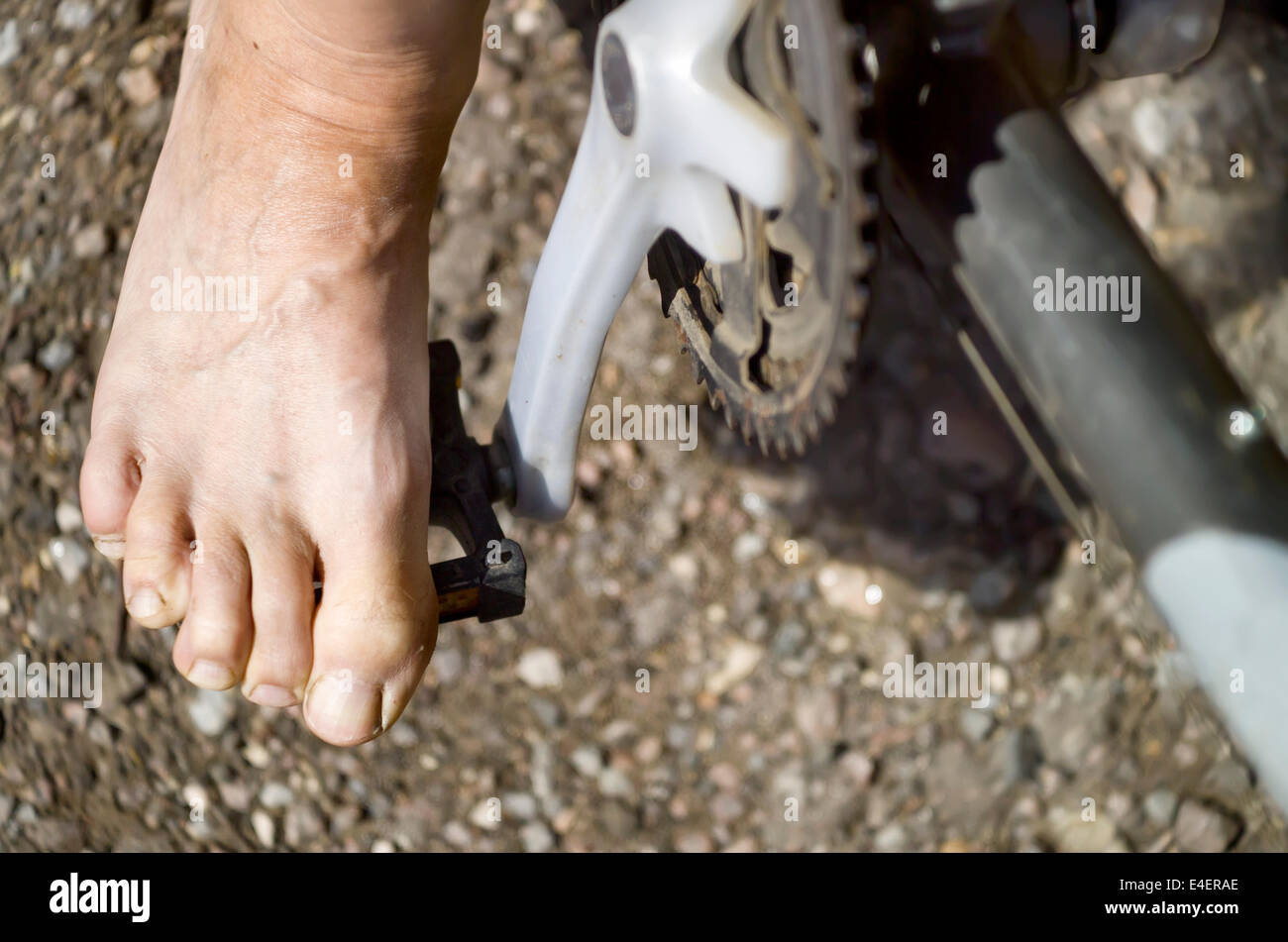 Overhead outdoor shot of a bared foot on a bicycle pedal, concept of