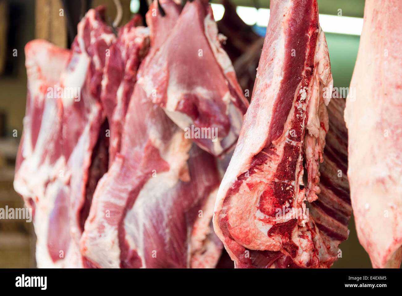 Chopped and cut meat hanging at the market in Old Delhi, India Stock Photo