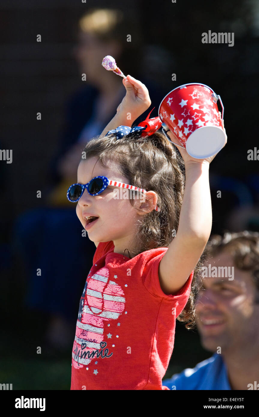 Young Girl Cheering Along the Parade Route as her Father Looks On during the 184th Pekin Independence Day Parade in Indiana Stock Photo