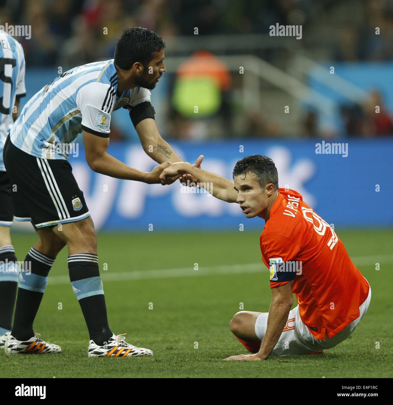 Sao Paulo, Brazil. 9th July, 2014. Argentina's Ezequiel Garay (L) pulls up Netherlands' Robin van Persie during a semifinal match between Netherlands and Argentina of 2014 FIFA World Cup at the Arena de Sao Paulo Stadium in Sao Paulo, Brazil, on July 9, 2014. Credit:  Wang Lili/Xinhua/Alamy Live News Stock Photo