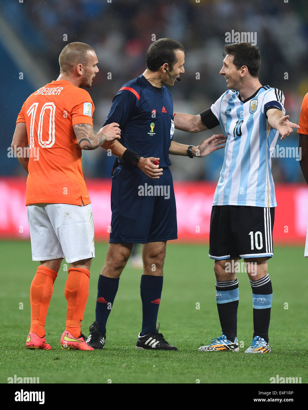 Sao Paulo, Brazil. 09th July, 2014. Turkish referee Cuneyt Cakir (C) talks to Argentina's Lionel Mesi (R) and Wesley Sneijder (L) of the Netherlands during the FIFA World Cup 2014 semi-final soccer match between the Netherlands and Argentina at the Arena Corinthians in Sao Paulo, Brazil, 09 July 2014. Photo: Marius Becker/dpa/Alamy Live News Stock Photo