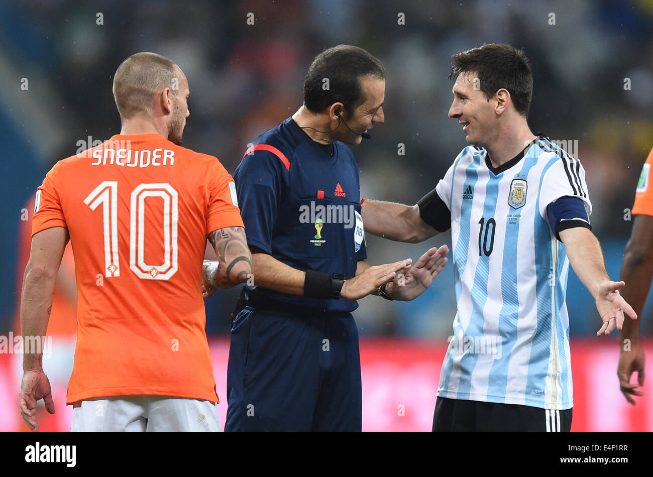 Sao Paulo, Brazil. 09th July, 2014. Turkish referee Cuneyt Cakir (C) talks to Argentina's Lionel Mesi (R) and Wesley Sneijder (L) of the Netherlands during the FIFA World Cup 2014 semi-final soccer match between the Netherlands and Argentina at the Arena Corinthians in Sao Paulo, Brazil, 09 July 2014. Photo: Marius Becker/dpa/Alamy Live News Stock Photo