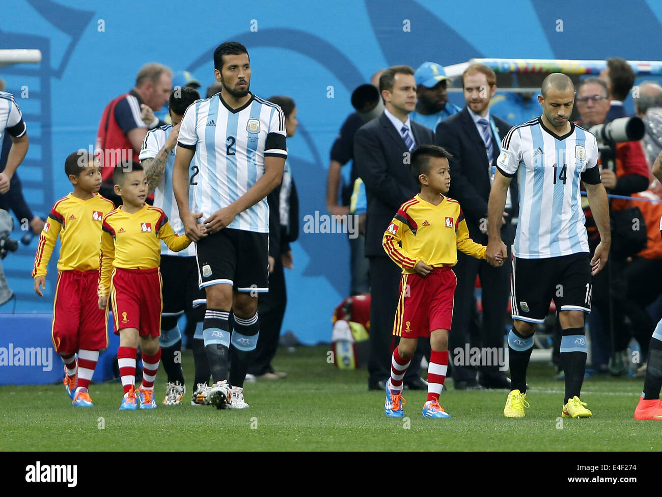 Sao Paulo, Brazil. 9th July, 2014. Argentina's Javier Mascherano (1st R) and Ezequiel Garay (3rd R) walk into the pitch with player escorts before a semifinal match between Netherlands and Argentina of 2014 FIFA World Cup at the Arena de Sao Paulo Stadium in Sao Paulo, Brazil, on July 9, 2014. Credit:  Zhou Lei/Xinhua/Alamy Live News Stock Photo