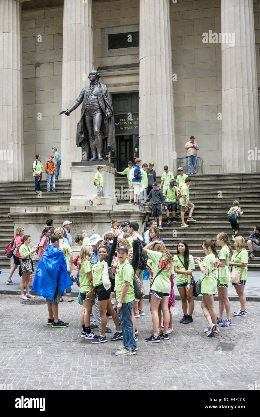 group New York middle school kids in matching tee shirts cluster below iconic George Washington statue as boys climb pedestal Stock Photo