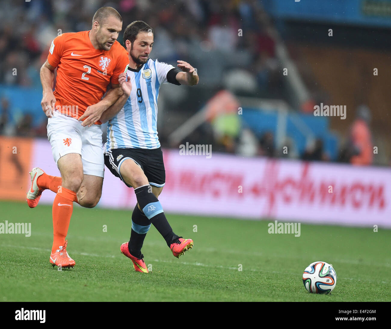 Sao Paulo, Brazil. 09th July, 2014. Gonzalo Higuain (R) of Argentina and Ron Vlaar of the Netherlands vie for the ball during the FIFA World Cup 2014 semi-final soccer match between the Netherlands and Argentina at the Arena Corinthians in Sao Paulo, Brazil, 09 July 2014. Photo: Marius Becker/dpa/Alamy Live News Stock Photo