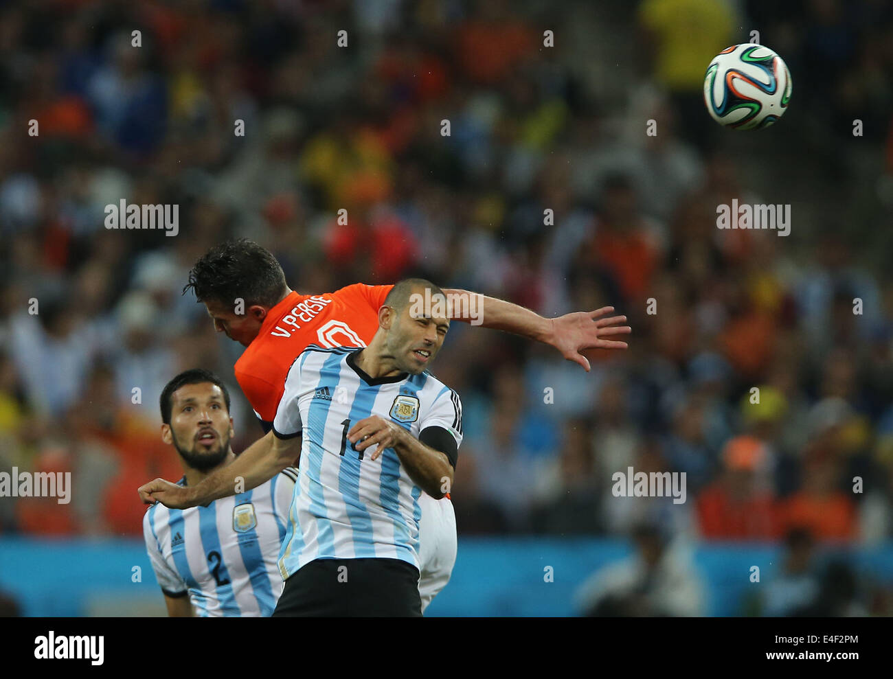 Sao Paulo, Brazil. 9th July, 2014. Netherlands' Robin van Persie (C) competes for a header with Argentina's Ezequiel Garay (L) and Javier Mascherano (R) during a semifinal match between Netherlands and Argentina of 2014 FIFA World Cup at the Arena de Sao Paulo Stadium in Sao Paulo, Brazil, on July 9, 2014. Credit:  Xu Zijian/Xinhua/Alamy Live News Stock Photo