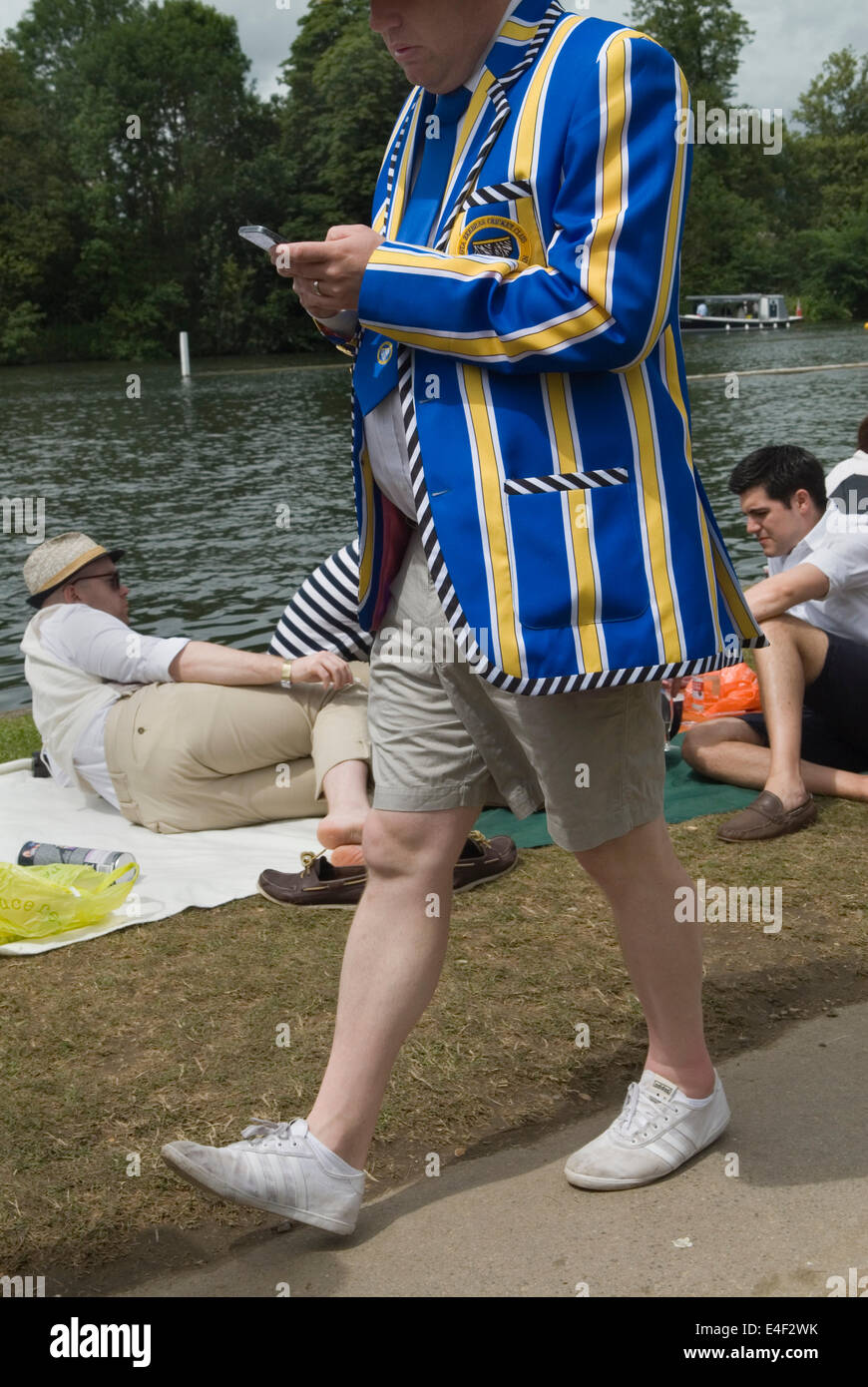 English man wearing shorts a shirt and tie fashion victim  and rowing club blazer. 22010s. UK. Henley Royal Regatta he is using a mobile devise iphone. 2014 Henley on Thames  Berkshire, England. HOMER SYKES Stock Photo