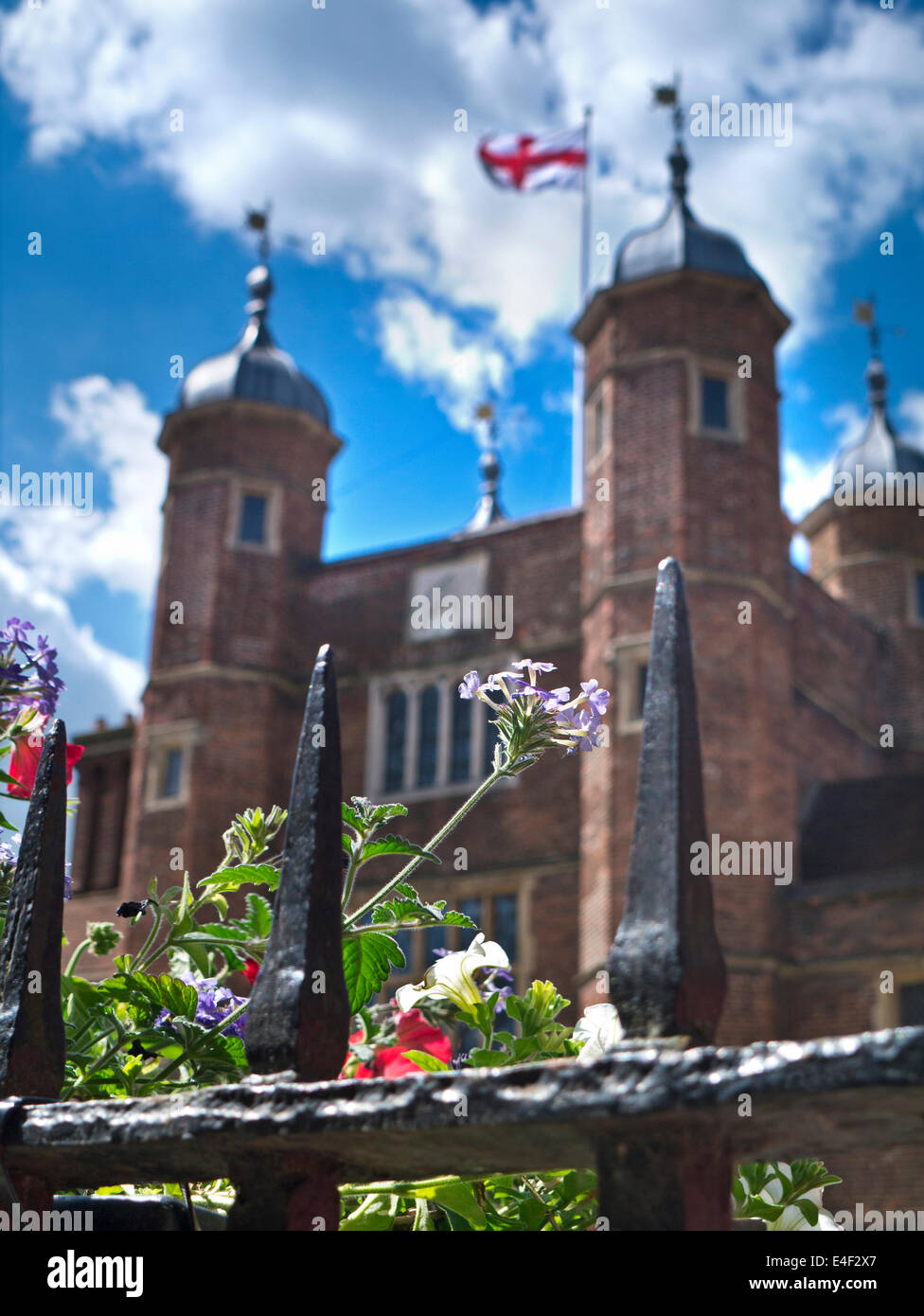 Historic Britain in summer with flowers in foreground and cross of St George on Abbot's Hospital Guildford Surrey UK Stock Photo