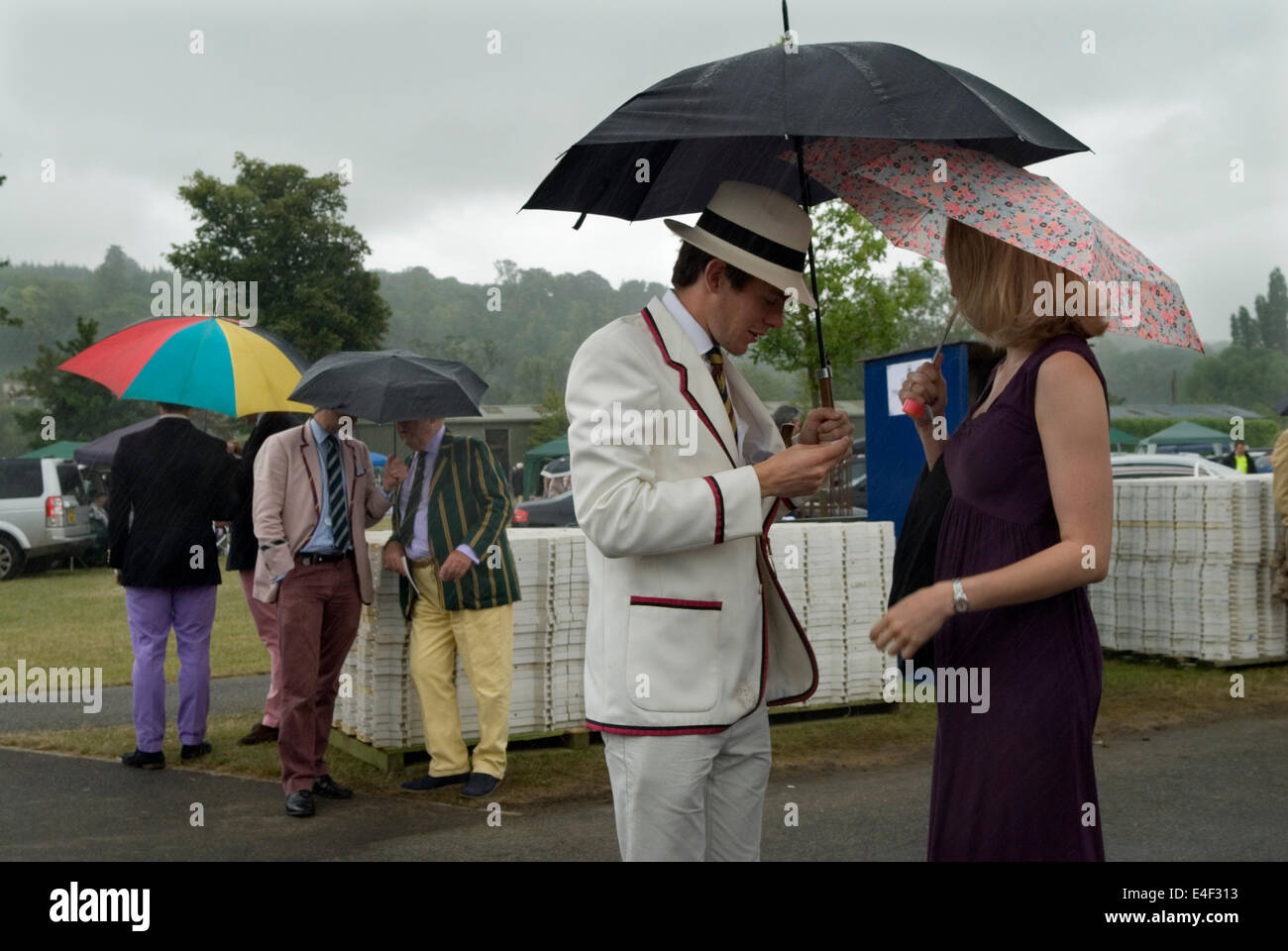 Embarrassed man looking for a mislaid lost ticket to get in to the Stewards Enclosure at Henley Royal Regatta. Rain storm Uk summer bad weather.  Henley on Thames, Oxfordshire, England, 2014, 2010s HOMER SYKES Stock Photo