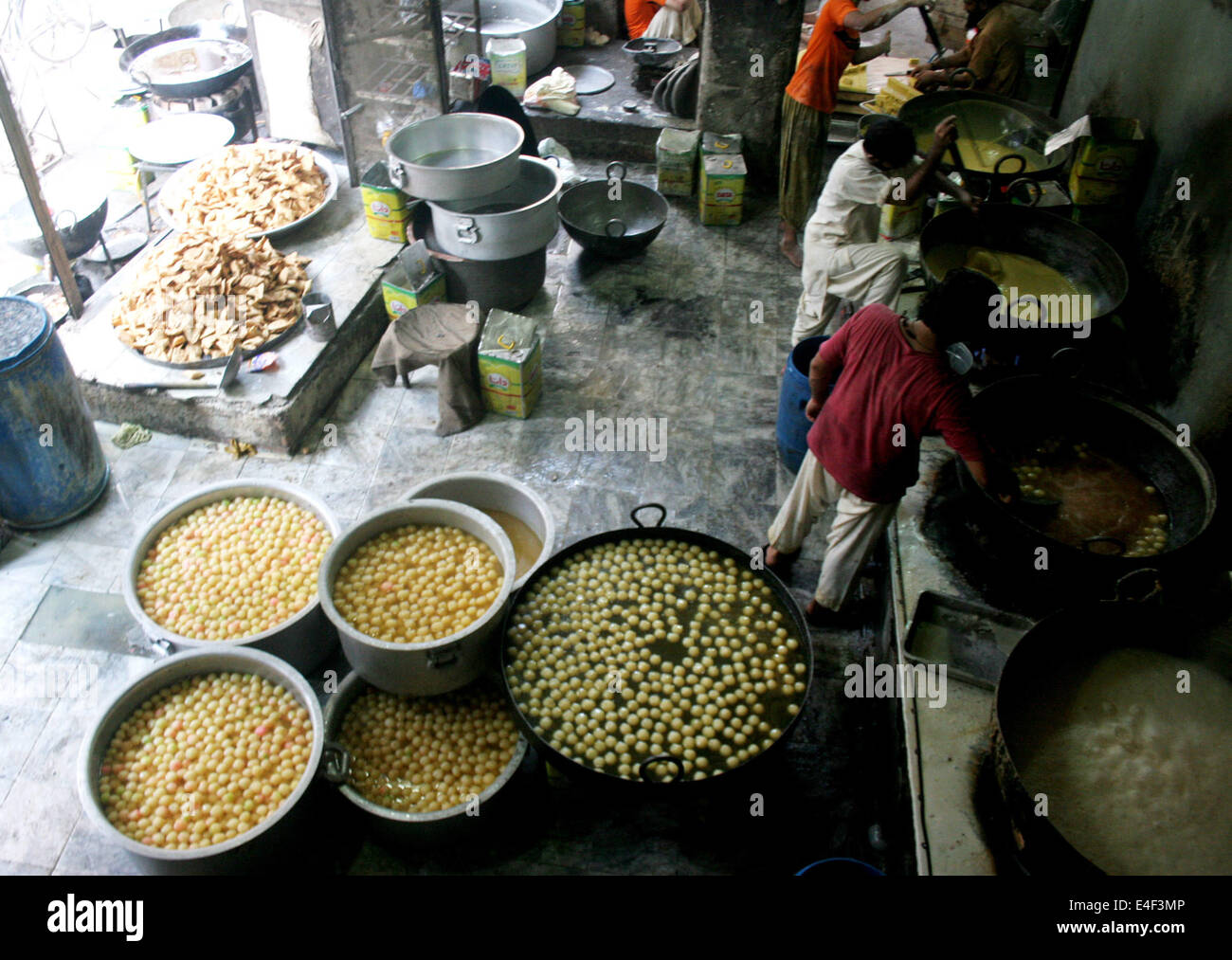 Peshawar. 9th July, 2014. Bakers prepare traditional sweets at a sweet factory in northwest