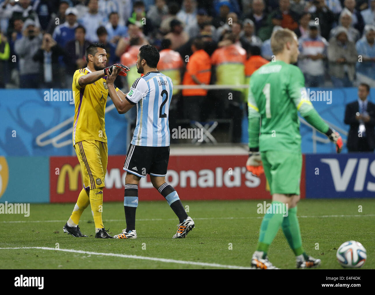 Sao Paulo, Brazil. 9th July, 2014. Argentina's Ezequiel Garay (C) celebrates with goalkeeper Sergio Romero (L) after scoring in the penalty shoot-out during a semifinal match between Netherlands and Argentina of 2014 FIFA World Cup at the Arena de Sao Paulo Stadium in Sao Paulo, Brazil, on July 9, 2014. Argentina won 4-2 on penalties over Netherlands after a 0-0 tie and qualified for the final on Wednesday. Credit:  Zhou Lei/Xinhua/Alamy Live News Stock Photo