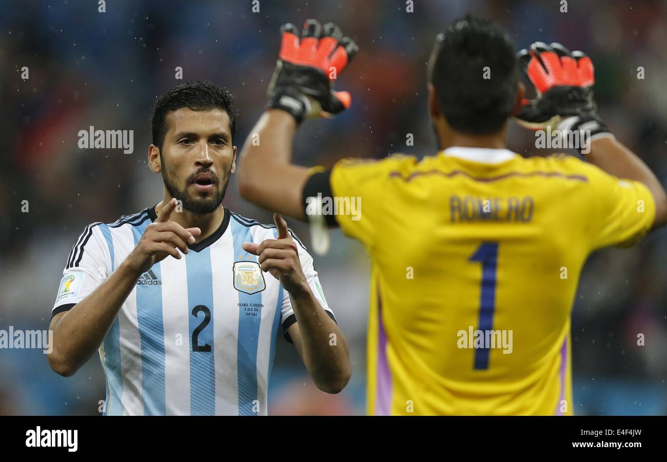 Sao Paulo, Brazil. 9th July, 2014. Argentina's Ezequiel Garay (L) celebrates with goalkeeper Sergio Romero after scoring in the penalty shoot-out during a semifinal match between Netherlands and Argentina of 2014 FIFA World Cup at the Arena de Sao Paulo Stadium in Sao Paulo, Brazil, on July 9, 2014. Argentina won 4-2 on penalties over Netherlands after a 0-0 tie and qualified for the final on Wednesday. Credit:  Wang Lili/Xinhua/Alamy Live News Stock Photo