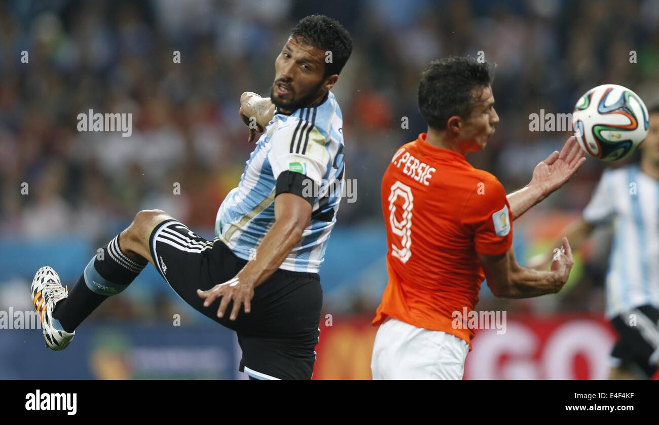 Sao Paulo, Brazil. 9th July, 2014. Argentina's Ezequiel Garay (L) vies with Netherlands' Robin van Persie during a semifinal match between Netherlands and Argentina of 2014 FIFA World Cup at the Arena de Sao Paulo Stadium in Sao Paulo, Brazil, on July 9, 2014. Argentina won 4-2 on penalties over Netherlands after a 0-0 tie and qualified for the final on Wednesday. Credit:  Wang Lili/Xinhua/Alamy Live News Stock Photo