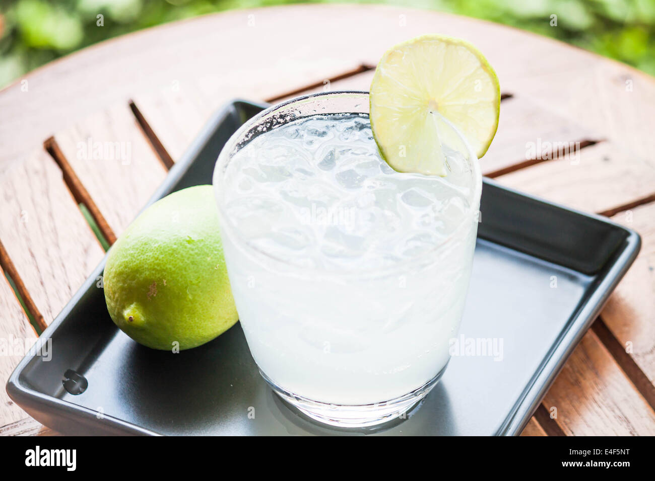 Tasty fresh lime juice with lime on wood table Stock Photo