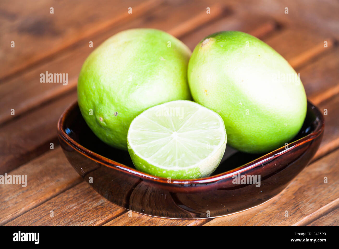 Fresh lime wholes and slice on wood table Stock Photo