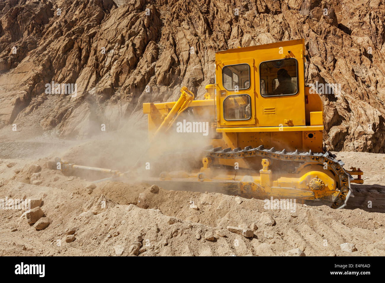 Bulldozer doing road construction in Himalayas. Ladakh, Jammu and Kashmir, India Stock Photo