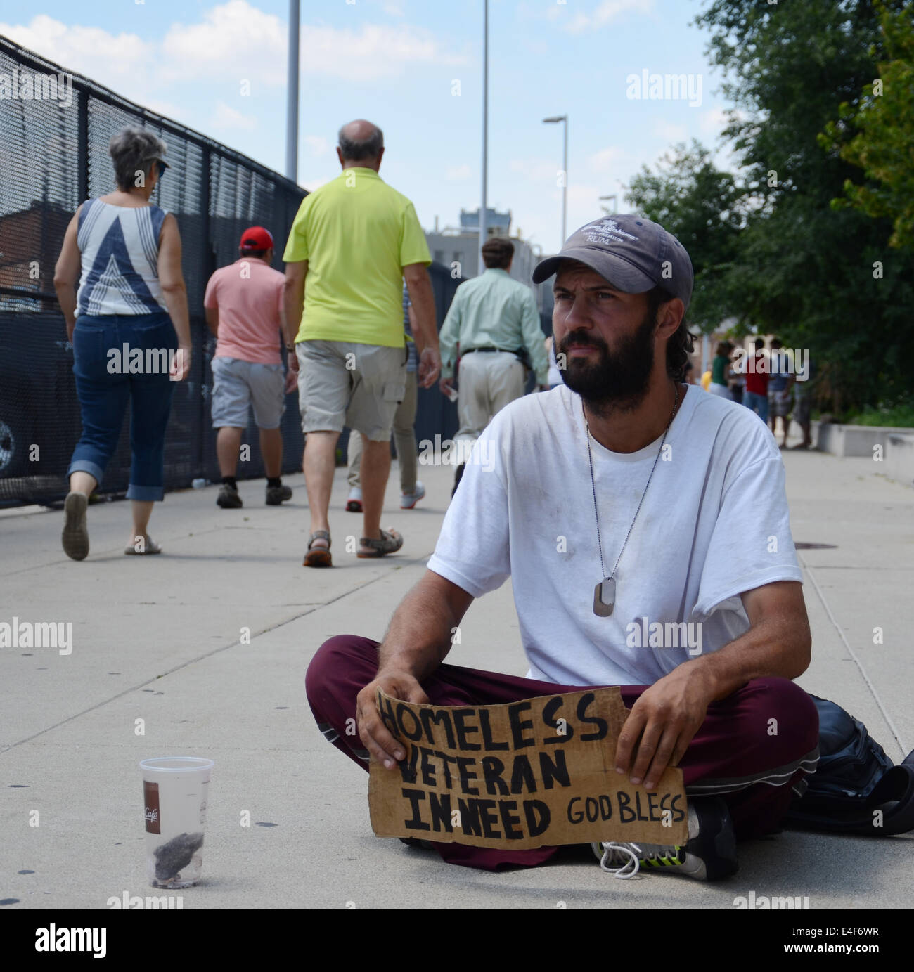 DETROIT, MI - JULY 6: Homeless veteran waits as people walk past him as he begs for money in Detroit, MI on July 6, 2014 Stock Photo