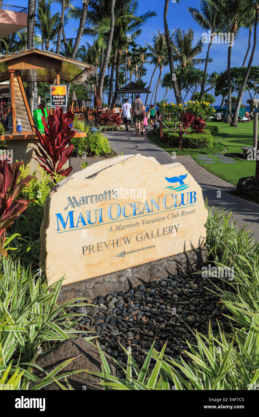 Tourists on the beach walk at Kaanapali Beach beyond sign for Marriott's Maui Ocean Club Stock Photo