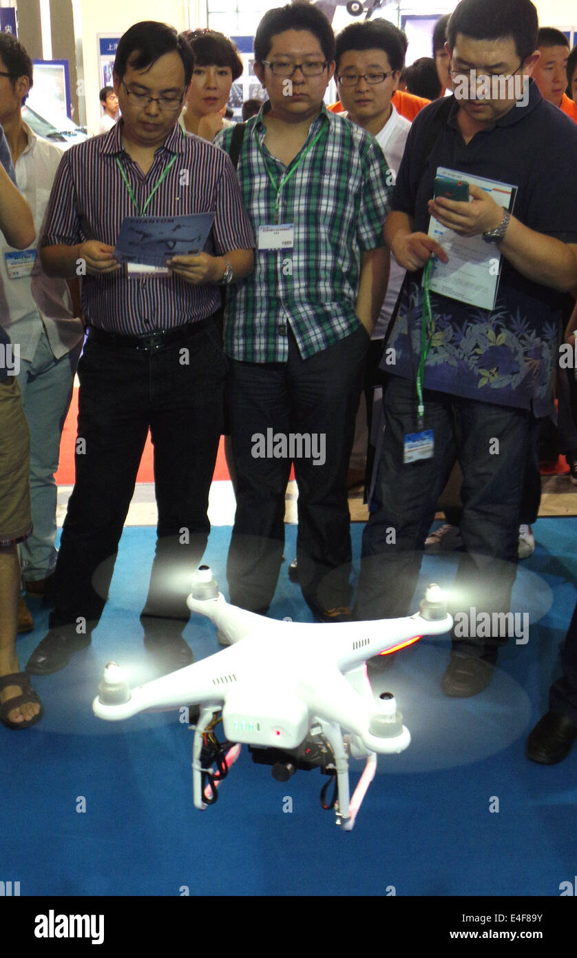 Beijing, China. 10th July, 2014. Visitors watch the performance of an unmanned aerial vehicle (UAV) displayed at a UAV Show in Beijing, capital of China, July 10, 2014. © Li Mingfang/Xinhua/Alamy Live News Stock Photo