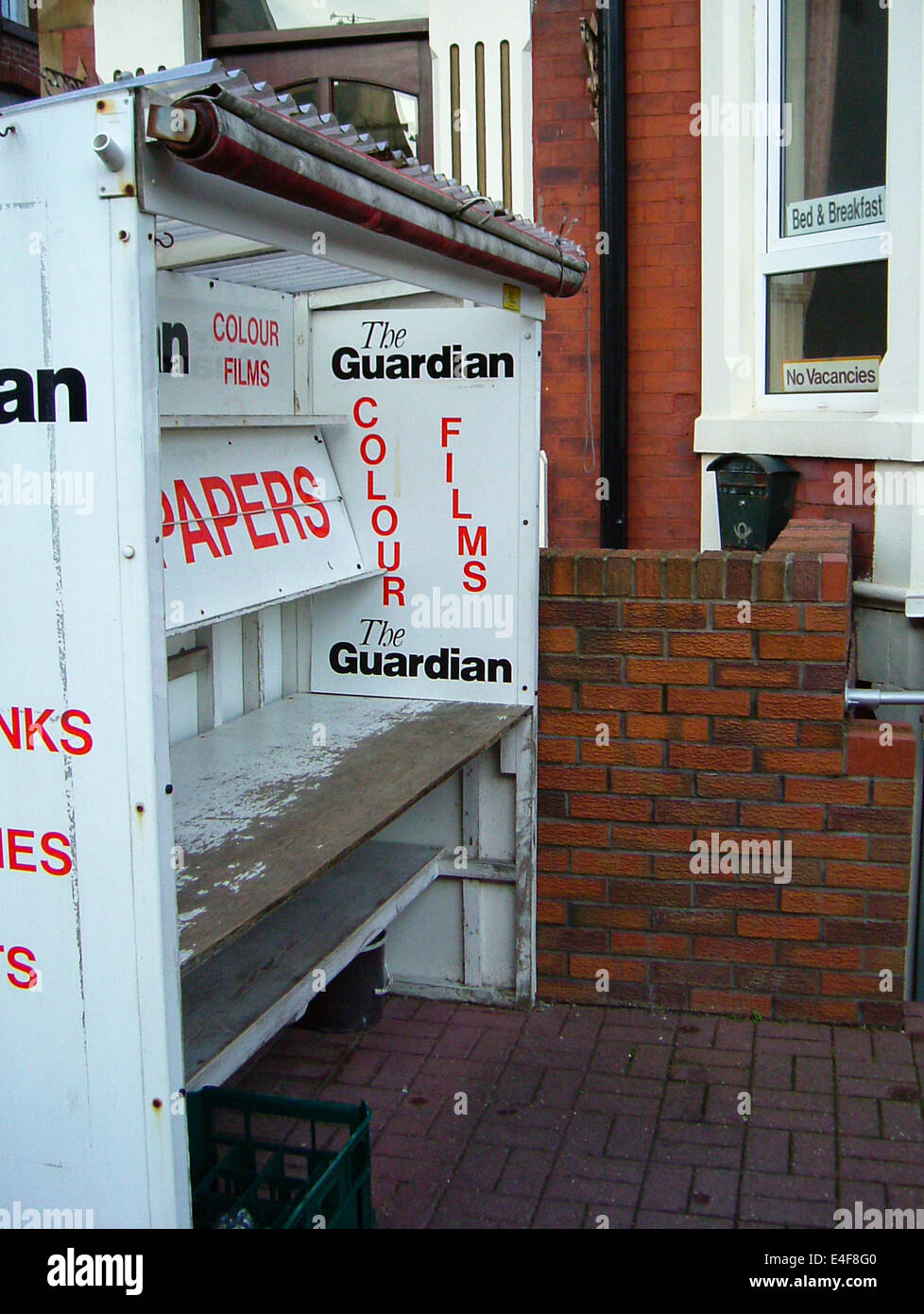 The Guardian Newspaper and Colour Films advertised on an old Newspaper stand outside a Blackpool B & B Stock Photo