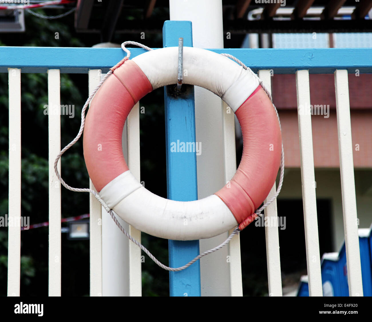 It's a photo of a lifebuoy attached to a hook fixed on a stick or grid near the sea ocean or swimming pool Stock Photo