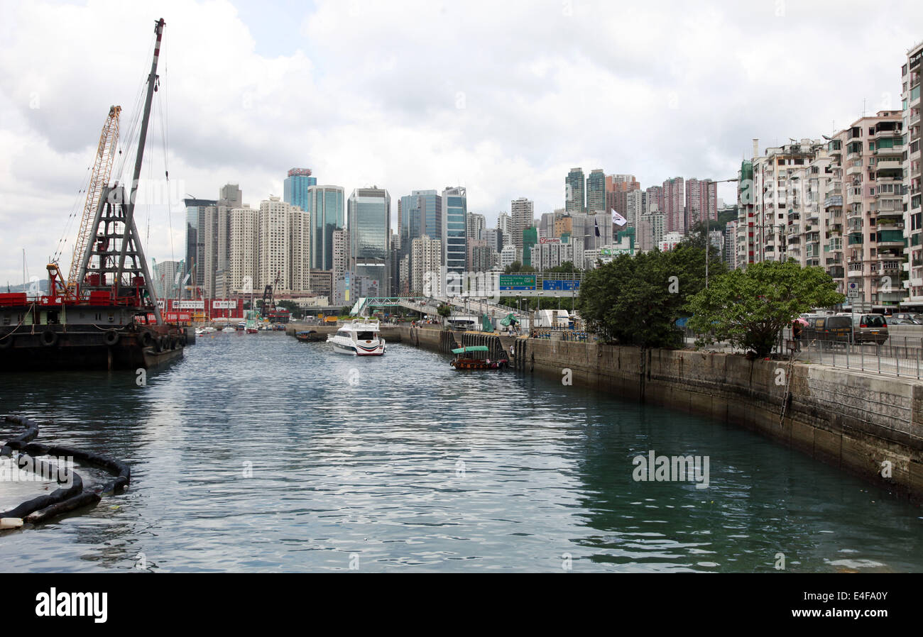 It's a photo of the harbor of Causeway Bay in Hong Kong Island. We see the platforms and some boats and ferries. Lots of Towers Stock Photo