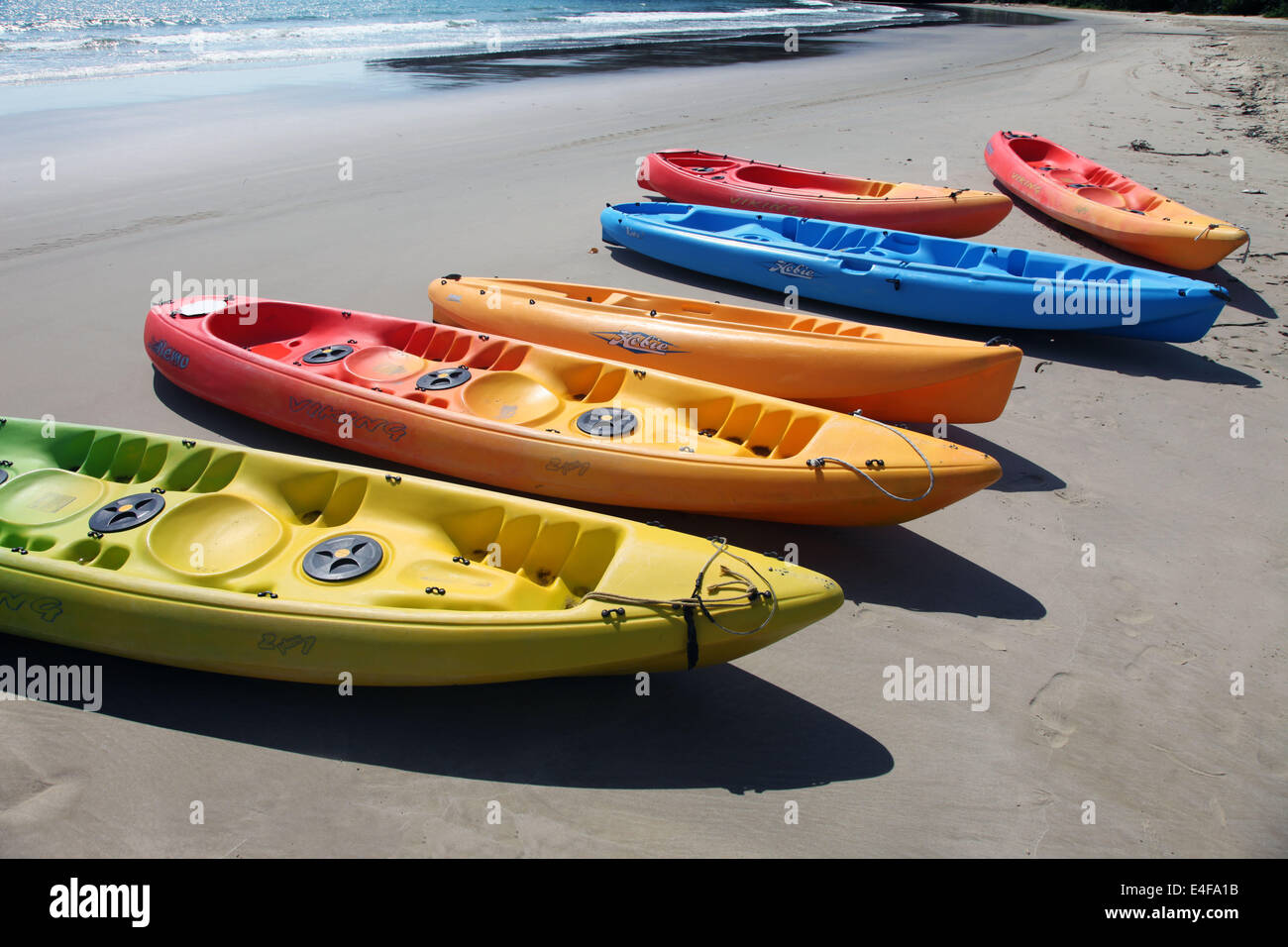 It's a picture of canoe on the beach. It's for water sport activity. Orange color. It's in a Water Sport Center near the sea Stock Photo