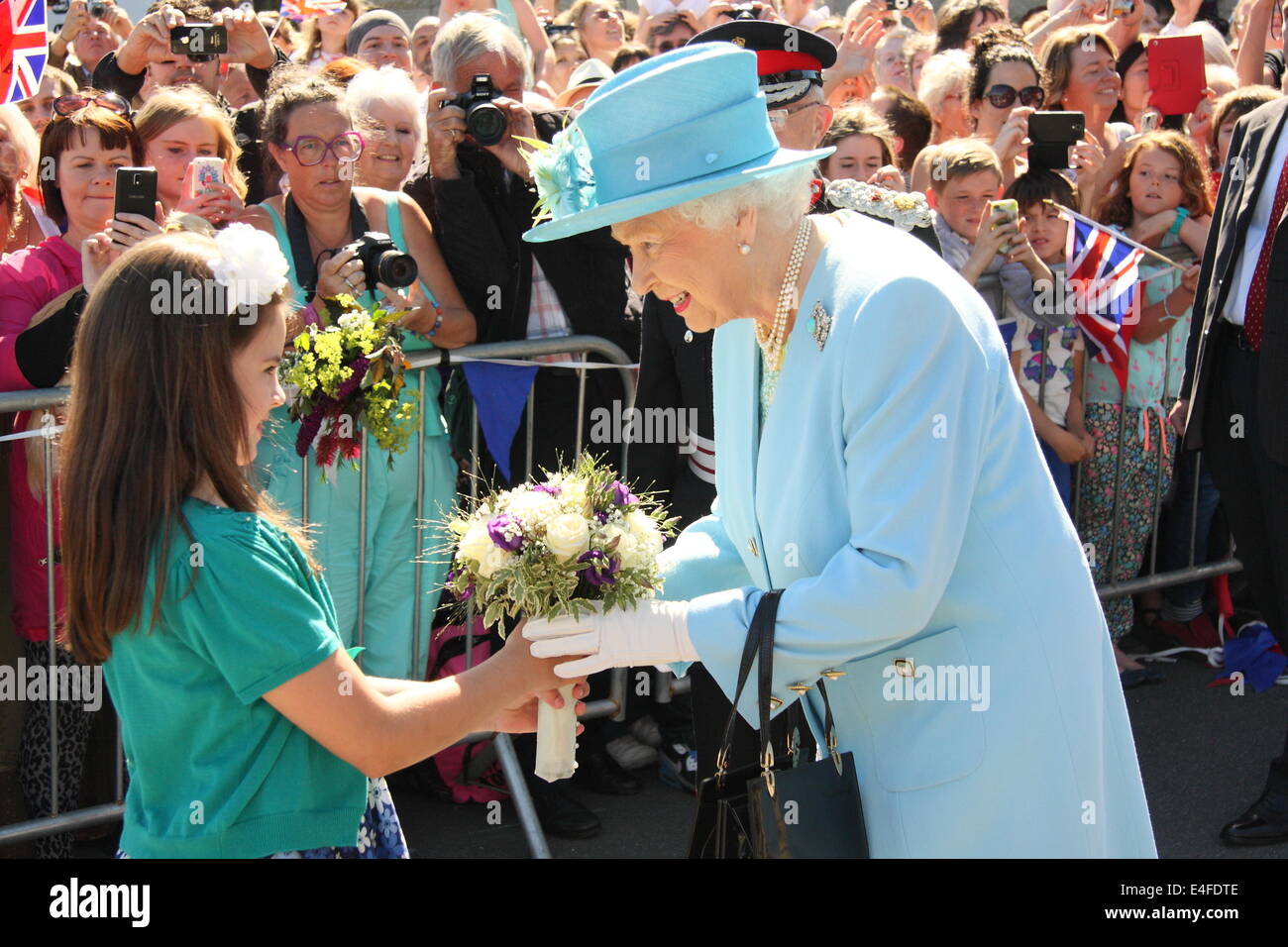 Matlock, Derbyshire, UK. 10th July 2014. Maggie Young, 8, from Walton-on-Trent in South Derbyshire presents Queen Elizabeth II with a posy on her arrival at Matlock Station.. Credit:  Matthew Taylor/Alamy Live News Stock Photo