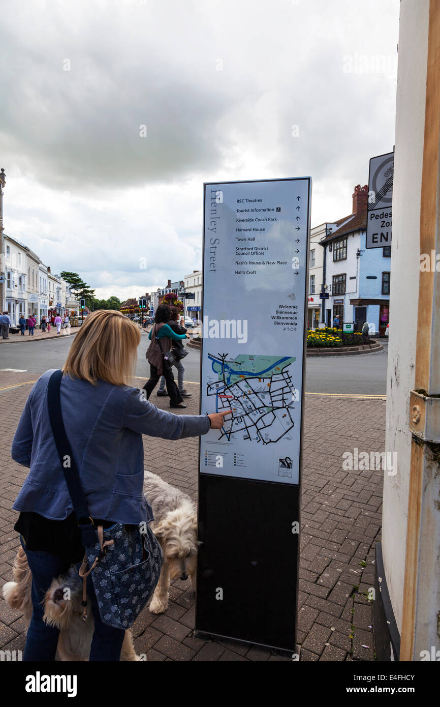 Lady pointing looking at sign map details places of interest in Stratford Upon Avon Cotswolds UK England Stock Photo