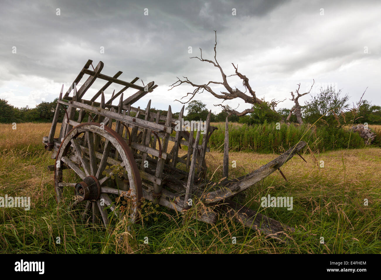 Old decrepit farming machinery antique farm cart holding pen with cartwheels Stock Photo