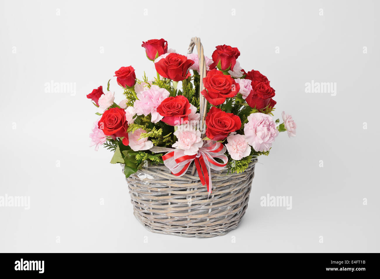 red roses and pink carnations in a basket Stock Photo Alamy