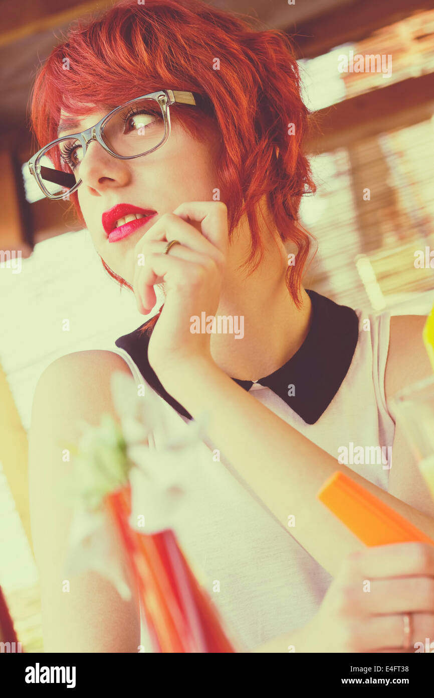 Cute hipster teenage girl in a coffee shop, daydreaming, looking away. Retro styled, toned image Stock Photo