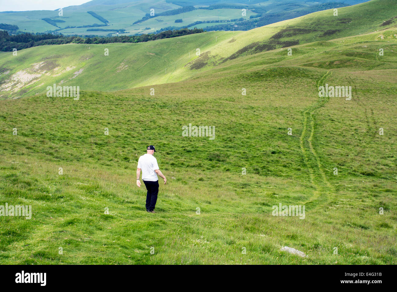 A man out walking in the hills in summer. Stock Photo