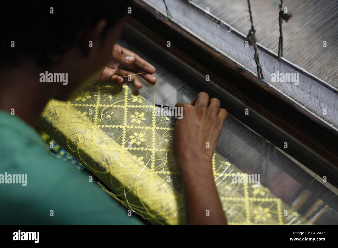 July 10, 2014 - Weavers weave famous Jamdani Saree.A sharee is the traditional garment worn by women in the Indian subcontinent. It is a long strip of unstitched cloth, ranging from five to nine yards in length, which can be draped in various style. The most common style is for the sari to be wrapped around the waist, with one end then draped over the shoulder.The Sharee boasts of the oldest existence in the world. It is more than 5,000 years old! Some people think that sharee is influenced by Greek or Roman toga, which we see on ancient statues. Stock Photo